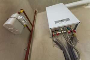 Weiße Gastherme an einer Wand, daneben ein Gaszähler und Kupferrohre