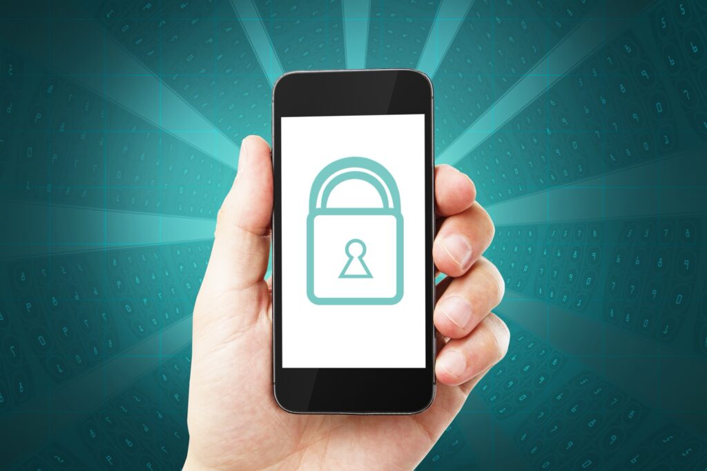 Hand hält ein Smartphone, auf dessen Bildschirm ein leuchtendes Vorhängeschloss als Symbol für Datenschutz zu sehen ist
