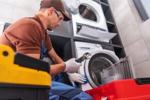Techniker repariert eine Waschmaschine mit einem Schraubenschlüssel
