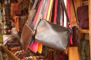 Bunte Leder- und Handtaschen hängen dicht an dicht an einem Marktstand